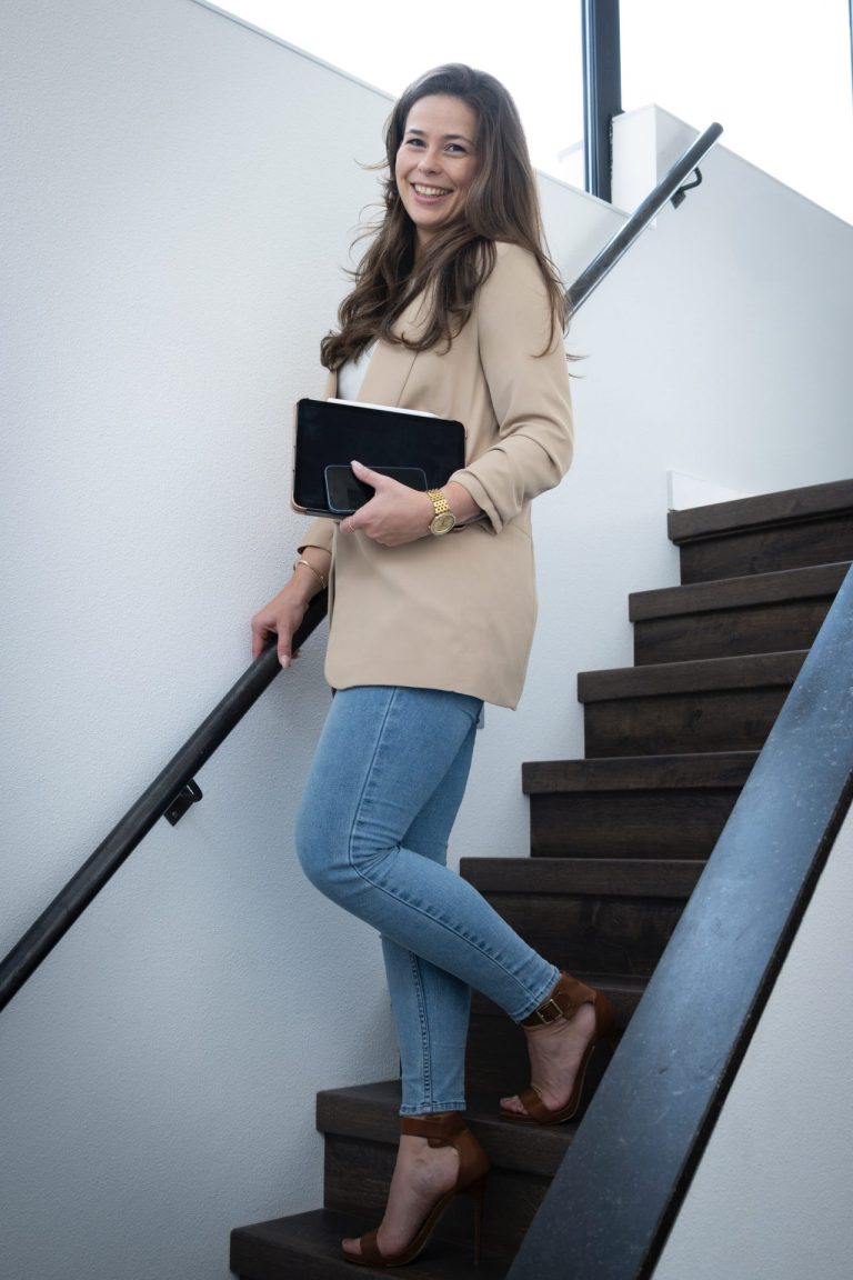 Veerle Bex staand met een tablet bij de trap