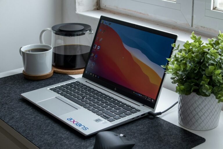 Laptop en een beker op een donker bureau